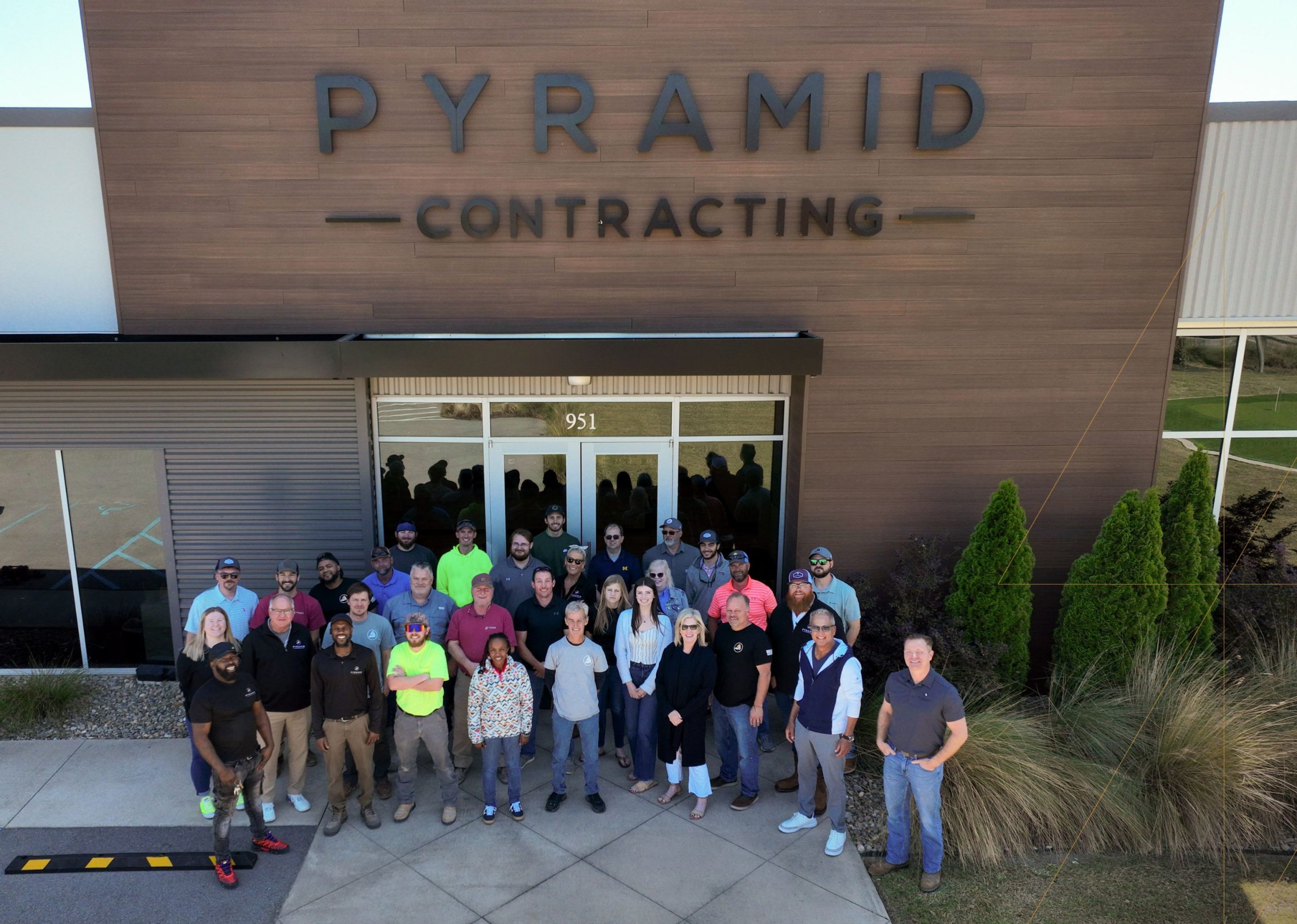 Boot Day Edited Group Photo 1 - Pyramid Contracting Group of Pyramid Contracting employees posing outside the office for a company group photo.