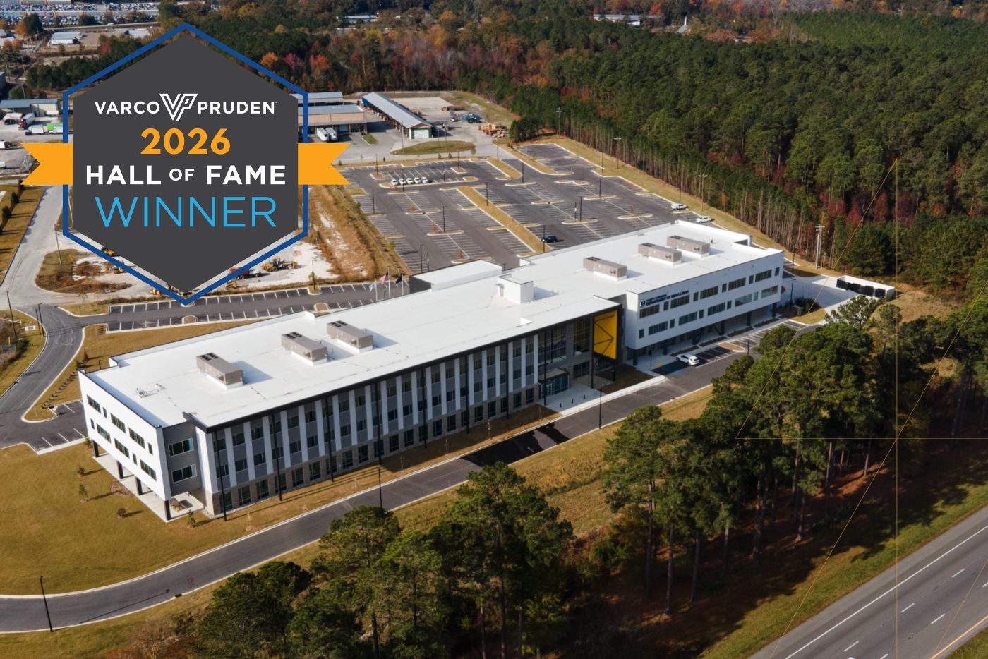 Aerial view of a large modern office building surrounded by trees, with a blue-and-orange '2026 Hall of Fame Winner' badge overlay.